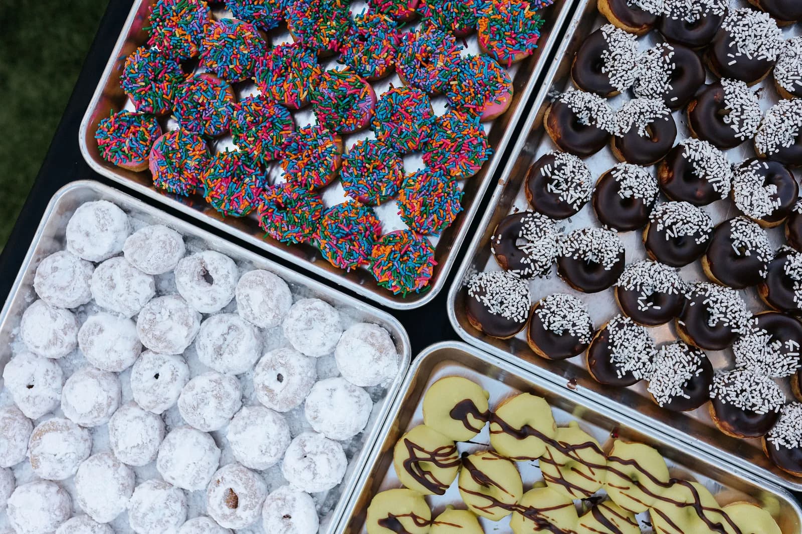 The Mini Donut Company trays of sprinkle, chocolate, and powdered mini donuts