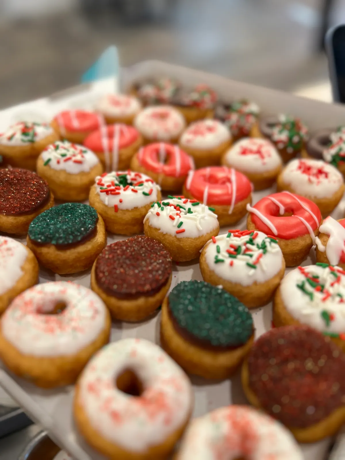 Box of holiday mini donuts with red green and white toppings